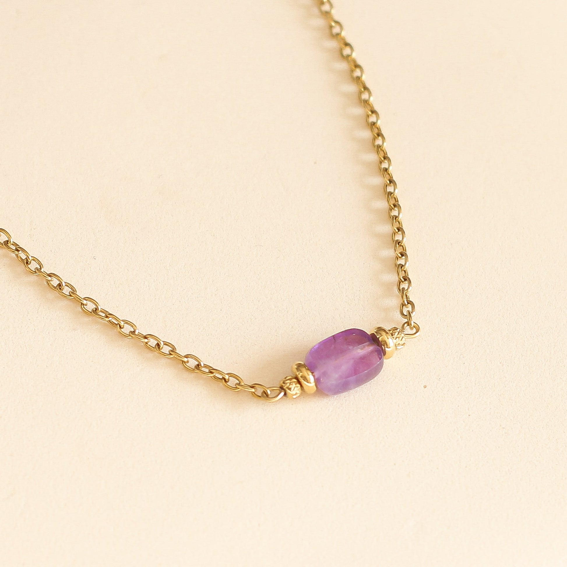 collier avec une pierre taillée d'Améthyste translucide sur une chaine dorée